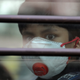 A schoolboy wearing a protective mask looks on from the inside of a school bus in Delhi.